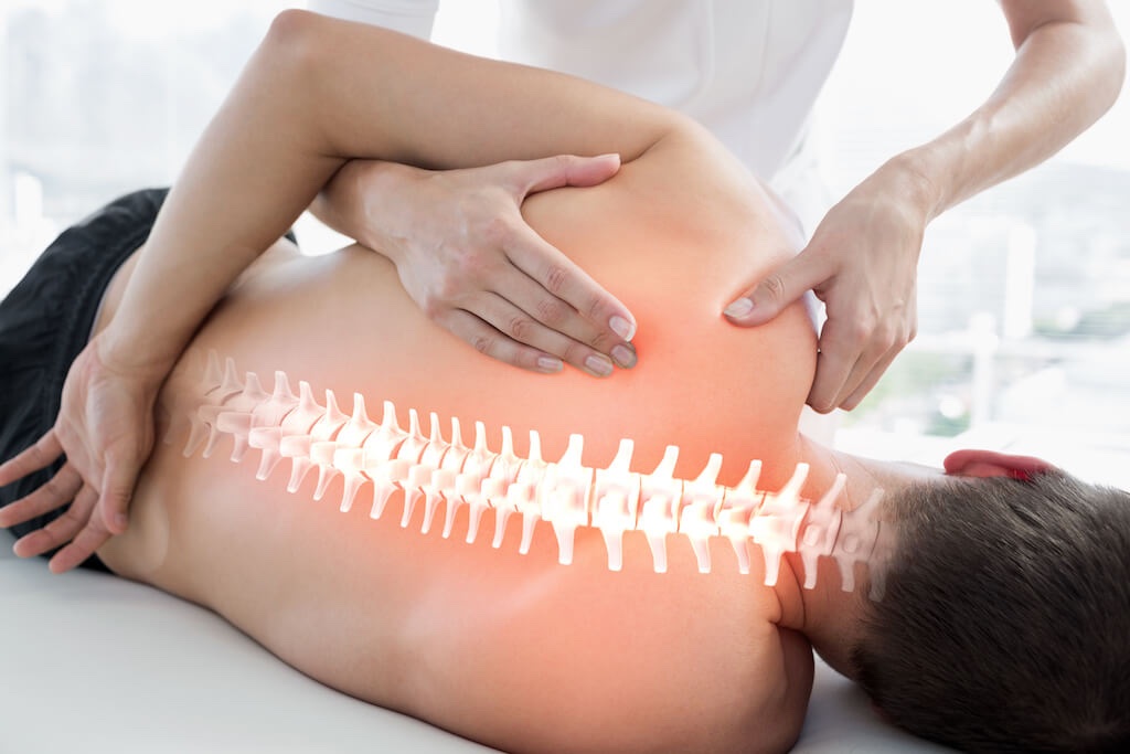Osteopaat behandelt de rug en schouder van een patiënt